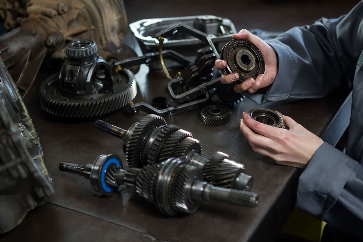 female-mechanic-holding-spare-parts-car