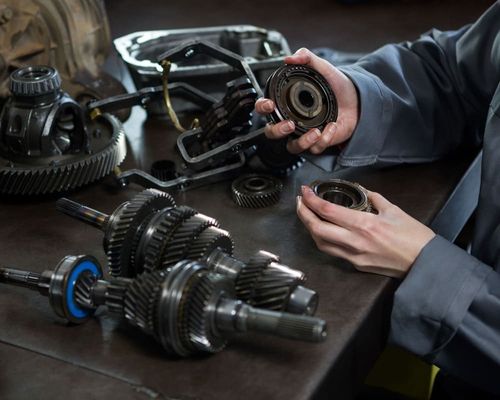 female-mechanic-holding-spare-parts-car